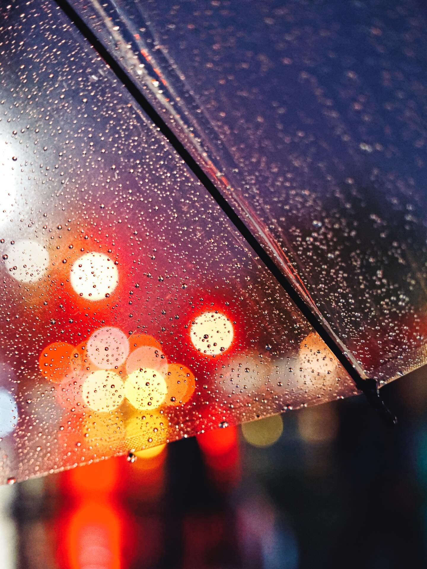 街のざわめきが雨に包まれる夜。傘の上を滑り落ちる無数の雫が、滲んだ光を小さな宝石のように閉じ込めてい...